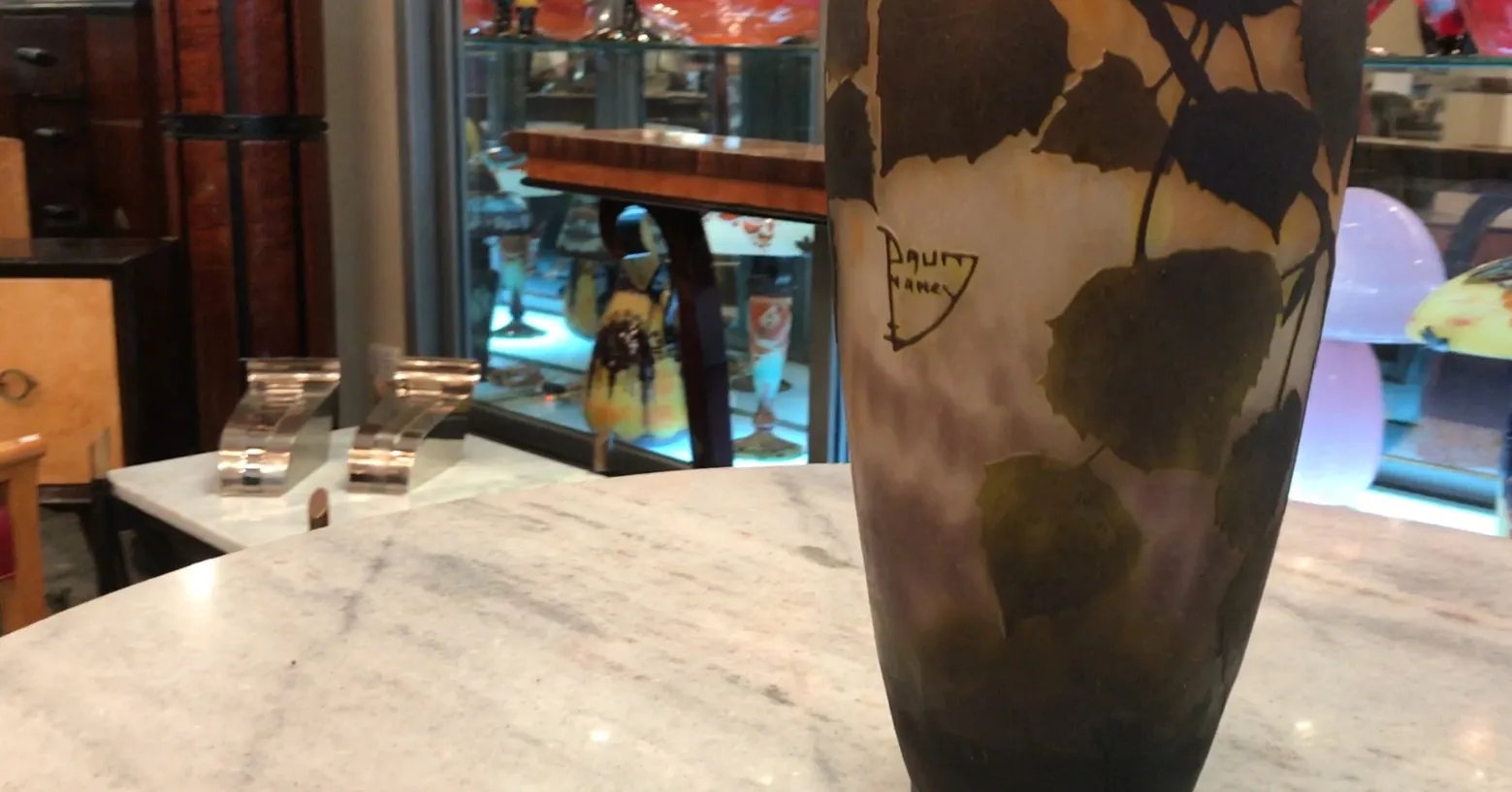 verre signé Daum Nancy avec motif de feuilles dans un cadre antique.