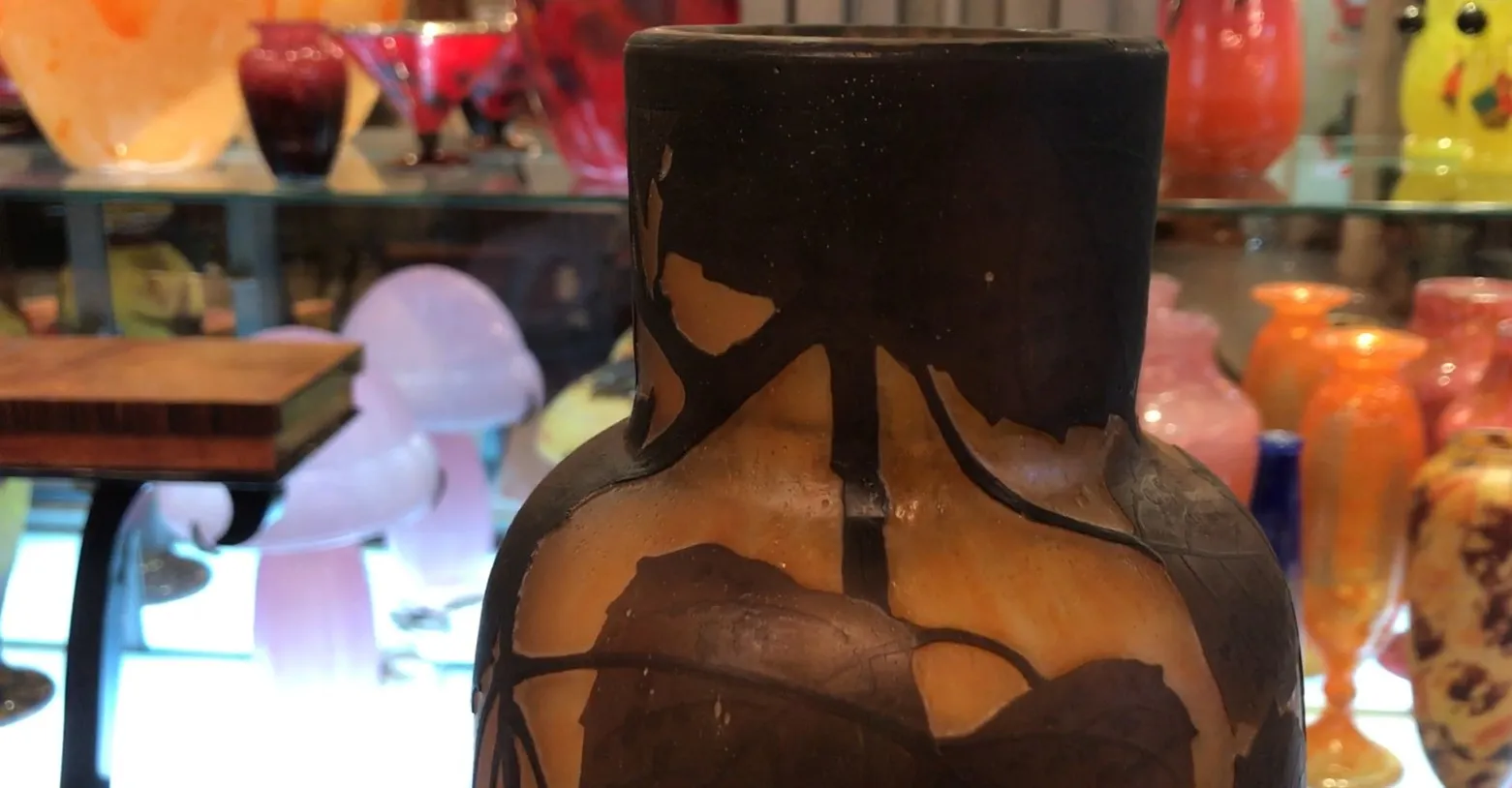 Verre ancien avec détails noirs et fond clair, signé Daum Nancy.