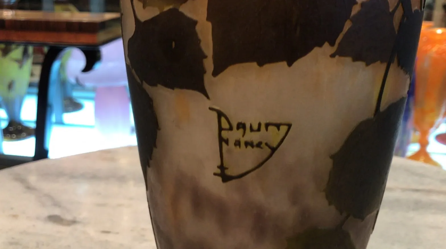 Antique signed glass by Daum Nancy with colorful design on a blurred background, perfect for collectors.