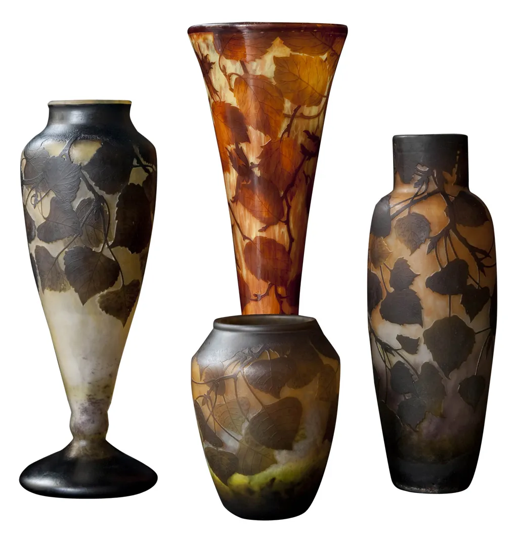 Four decorative vases of signed Daum Nancy glass featuring leaves. Antique design.