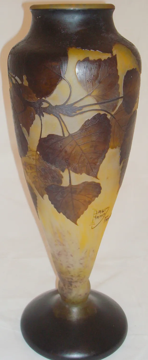 Vase ancien en verre signé Daum Nancy avec motif de feuilles.