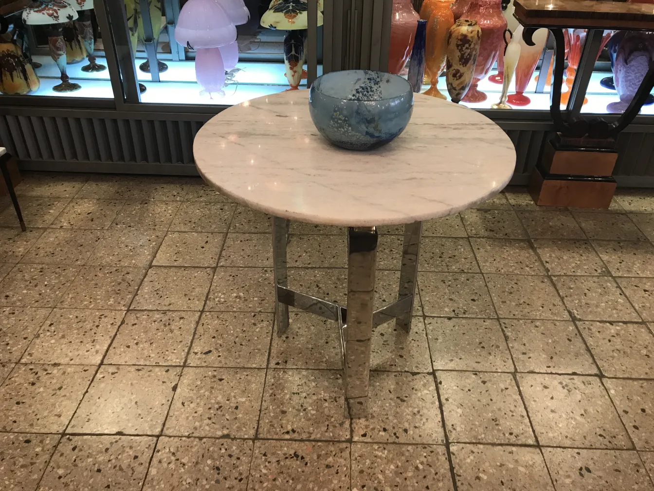 Runder Tisch mit Marmor und einer blauen Glasschüssel, Antike im Hintergrund