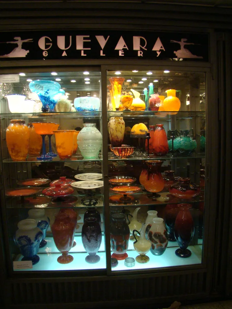 Antique display featuring signed glass Daum Nancy