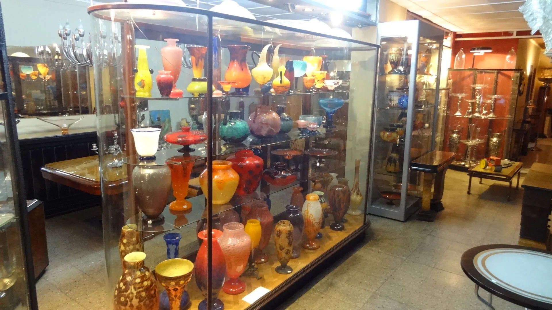 showcase with antiques, colorful glass pieces displayed