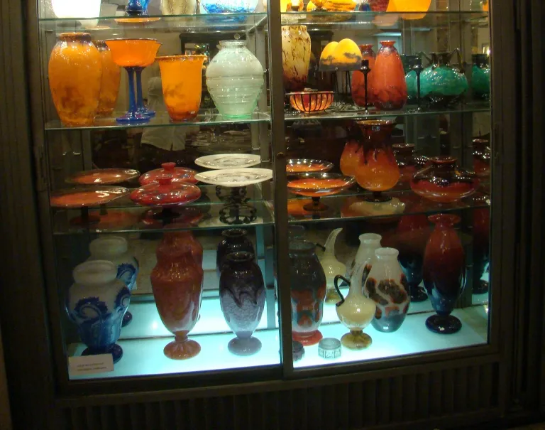 verre signé daum nancy exposé avec d'autres objets en verre colorés
