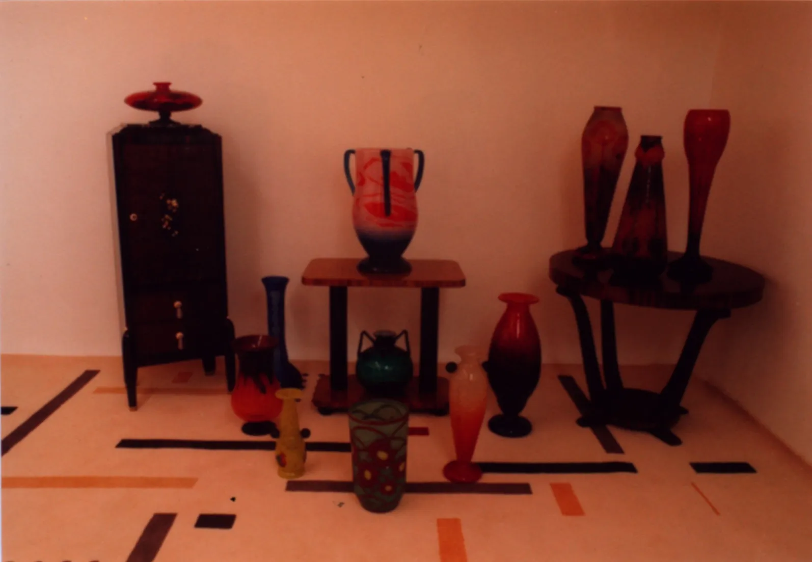 Vidro antigo assinado Daum Nancy com decorações coloridas em um ambiente decorativo.