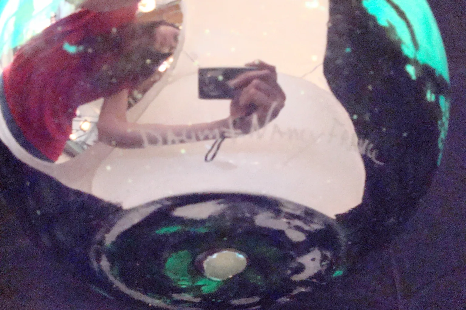 Vidro antigo assinado com tons verdes e azuis.