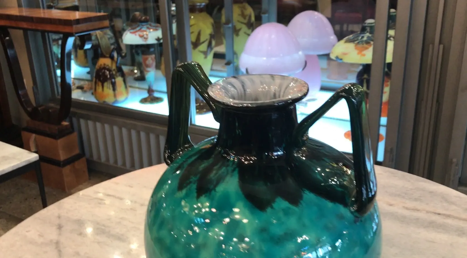 Vetro firmato Daum Nancy, colore verde con manici, decorato con dettagli visivi chiari, in un contesto di antiquariato.