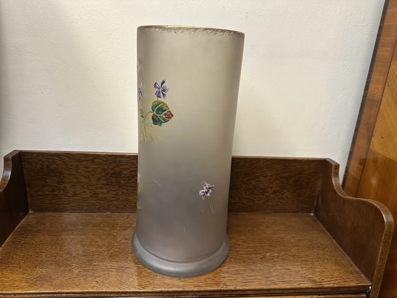 Un'elegante vaso in vetro firmato Daum Nancy decorato con fiori in un ambiente antico.