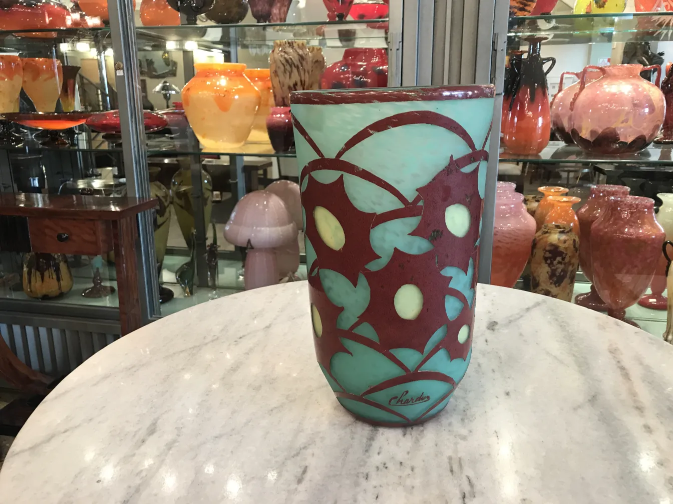 Signed glass Charder with colorful design on green backdrop