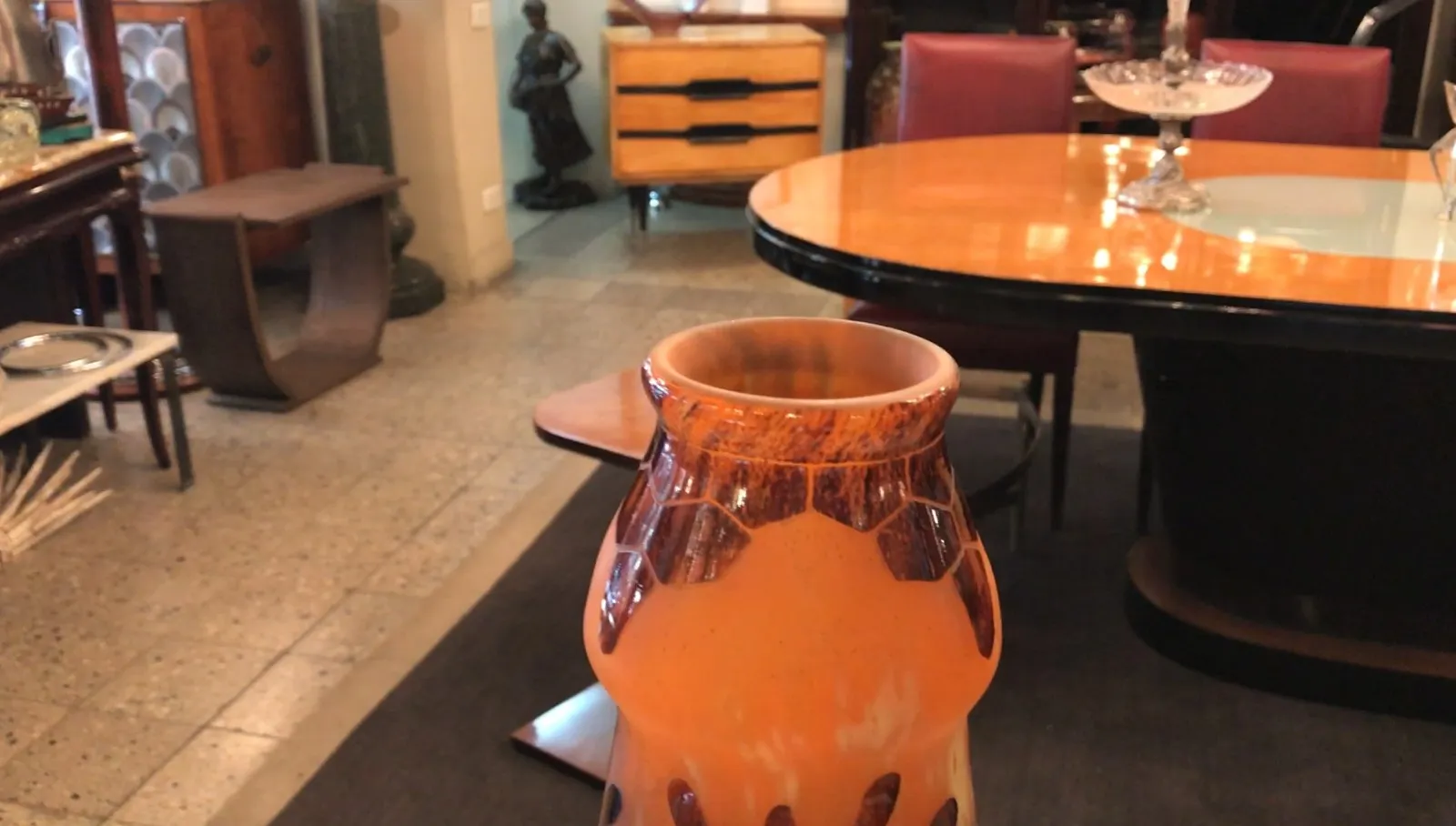 Signiertes Glas Charder in orange mit dekorativen Details, auf einem Tisch platziert.