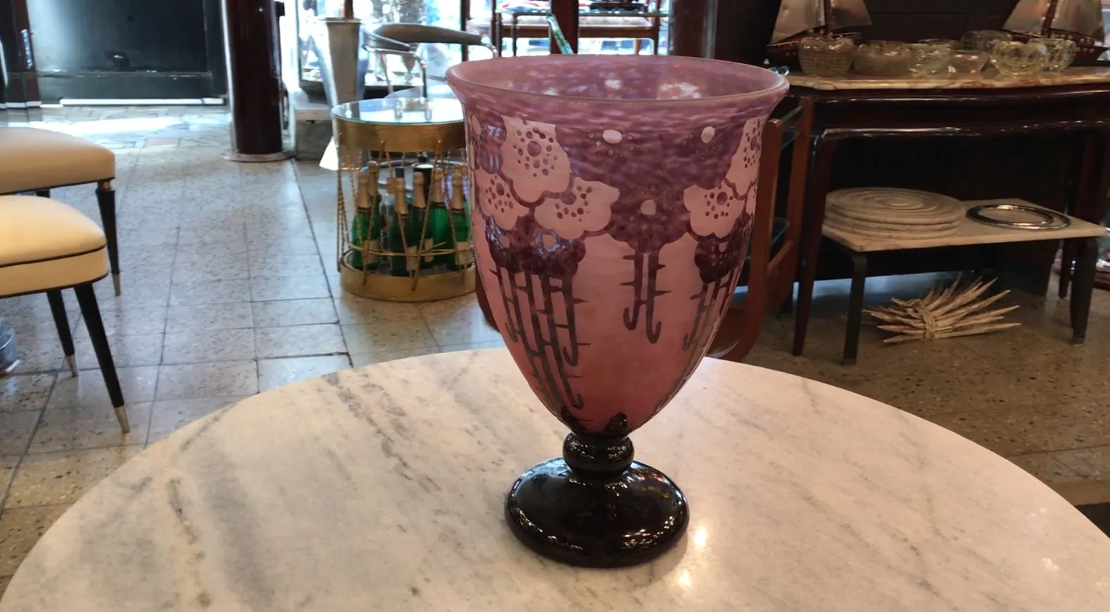 Antiguo vaso de vidrio firmado Charder con diseño floral en tonos púrpura sobre una base oscura.