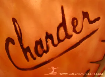 Dettaglio di un'antichità con la firma Charder sul vetro.