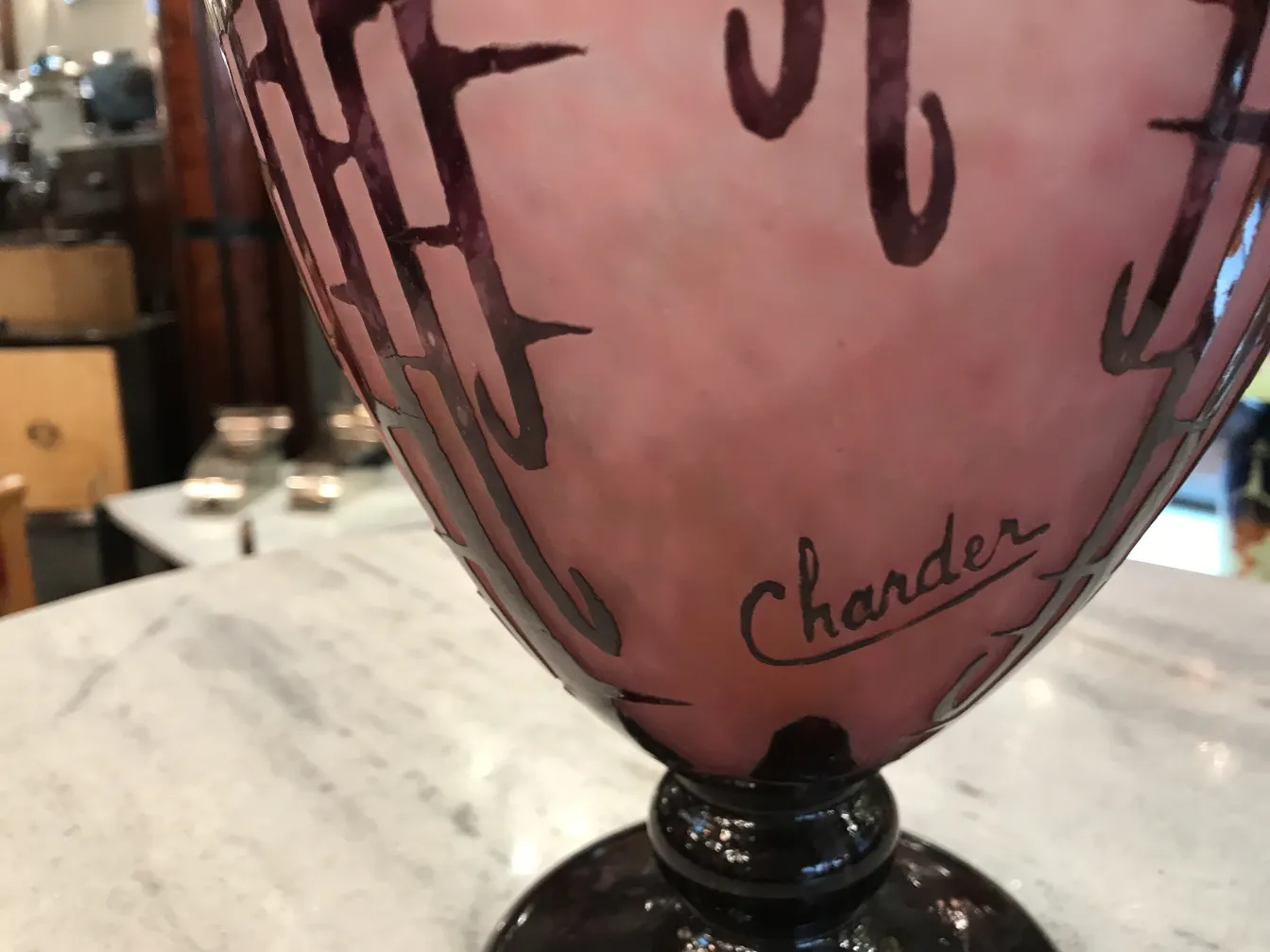 signed Charder glass with pink decoration, placed on a table