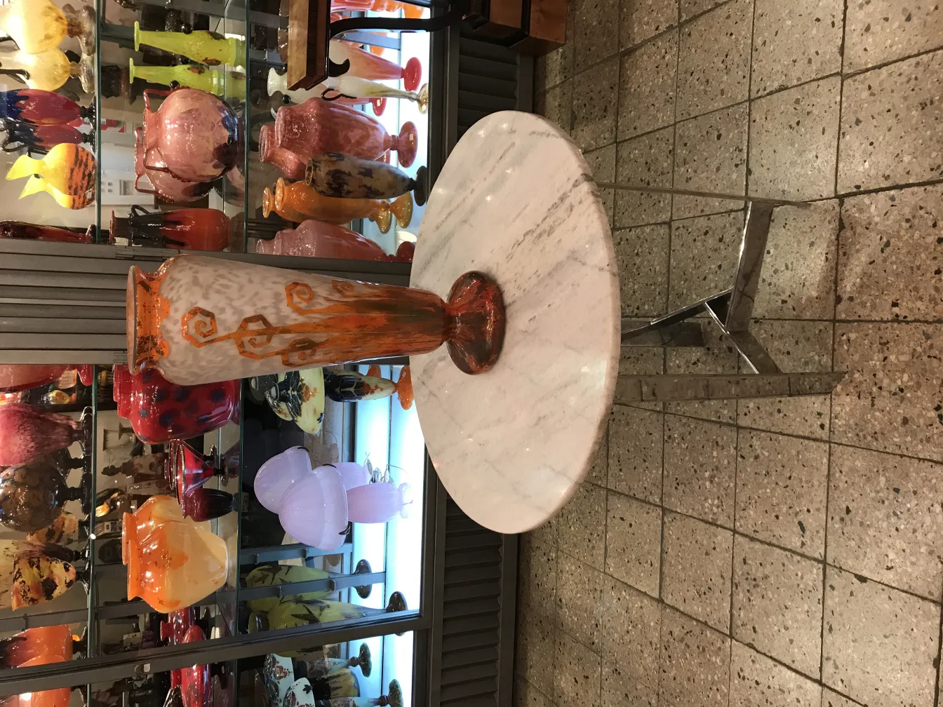 Vaso de vidro assinado com design colorido em exibição bem iluminada.