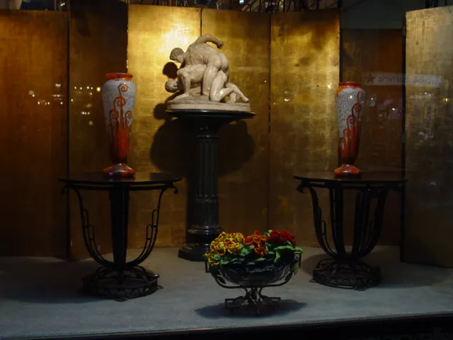 Vetro firmato Charder in un ambiente antico, con sculture e vasi decorativi.