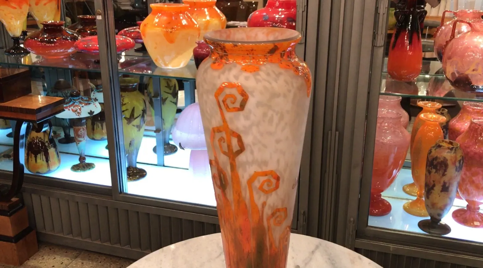 Antiguo vidrio firmado Charder con decoración naranja, fondo claro.