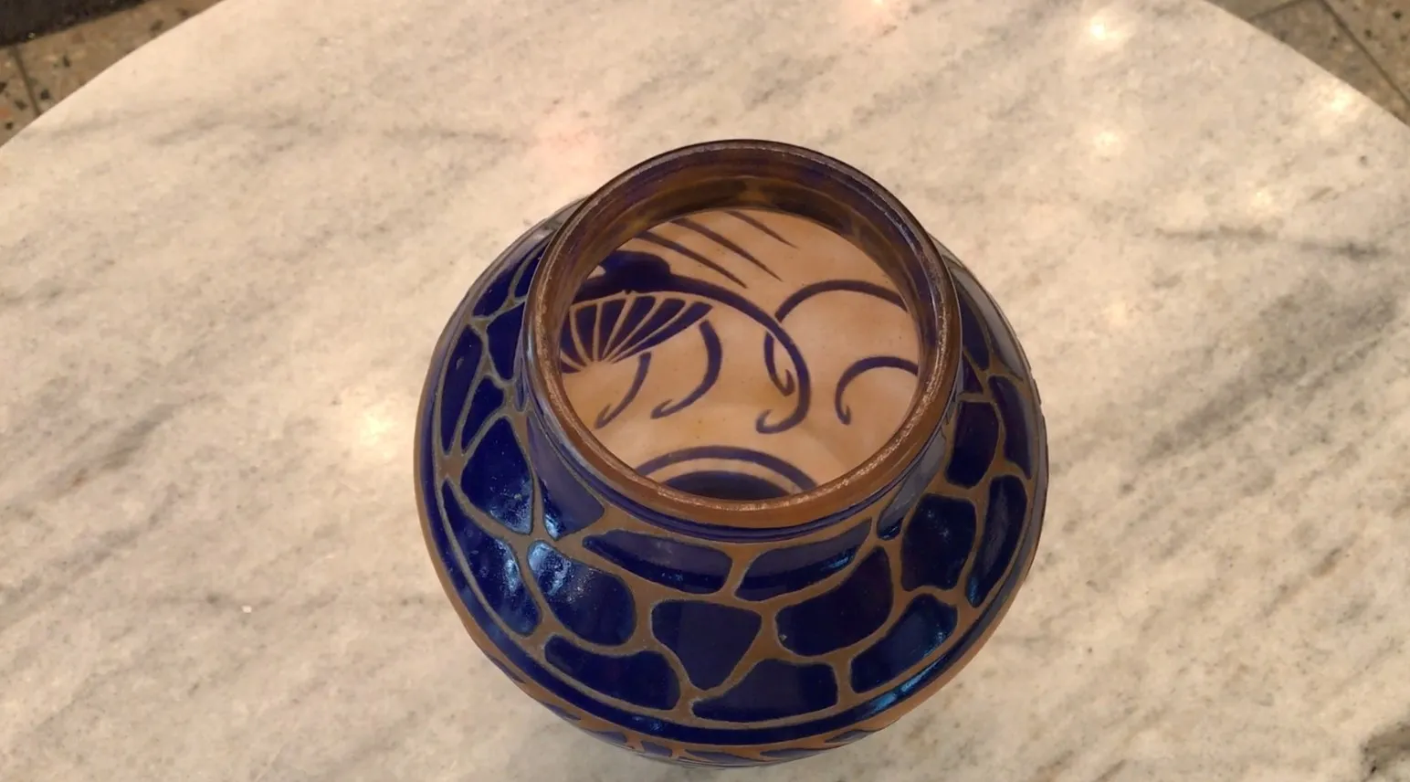 Vidrio firmado antiguo de Charder con diseño azul en un fondo claro.