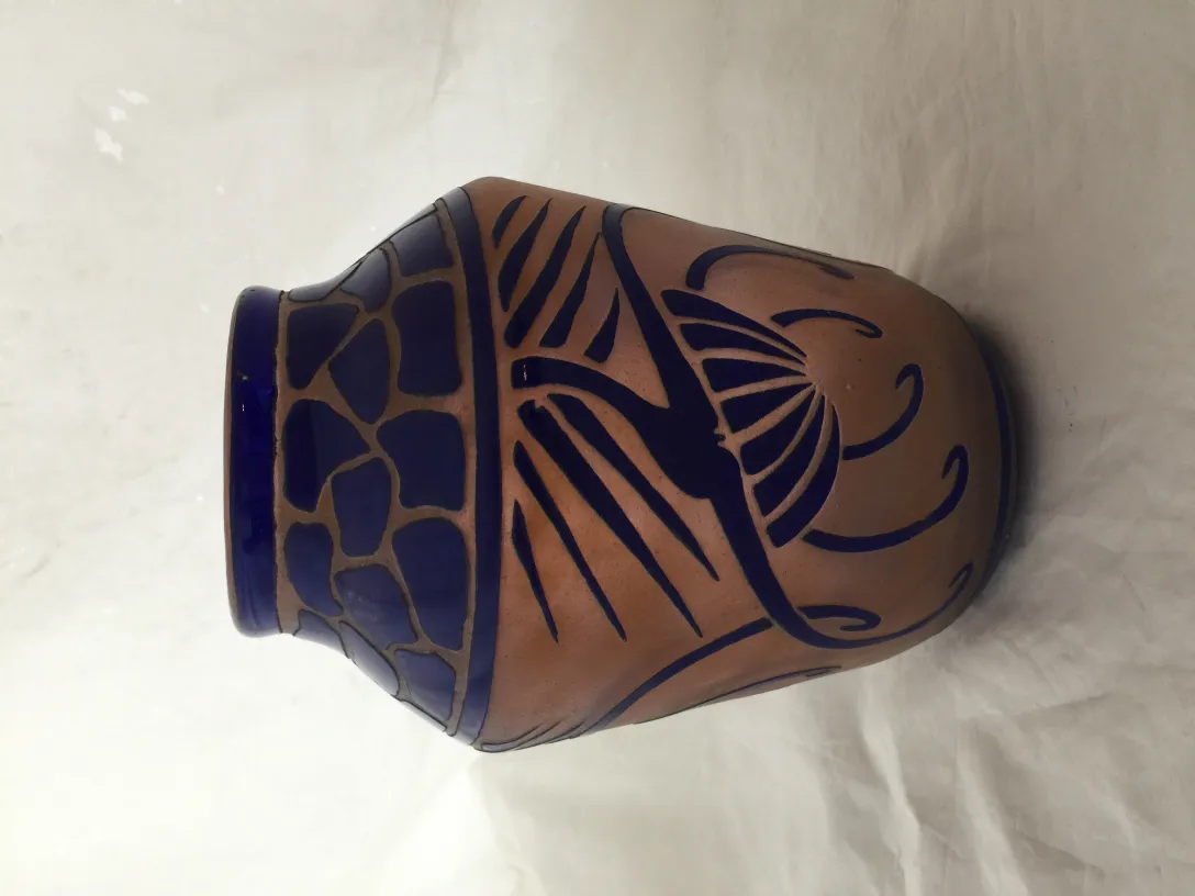 Vidrio antiguo con diseño azul, firmado por Charder, en fondo claro.