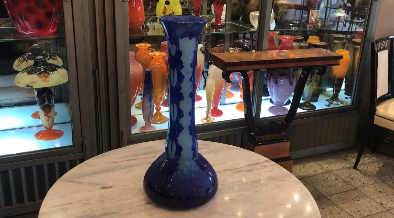 Blaues signiertes Glas Charder vor anderen bunten Gegenständen