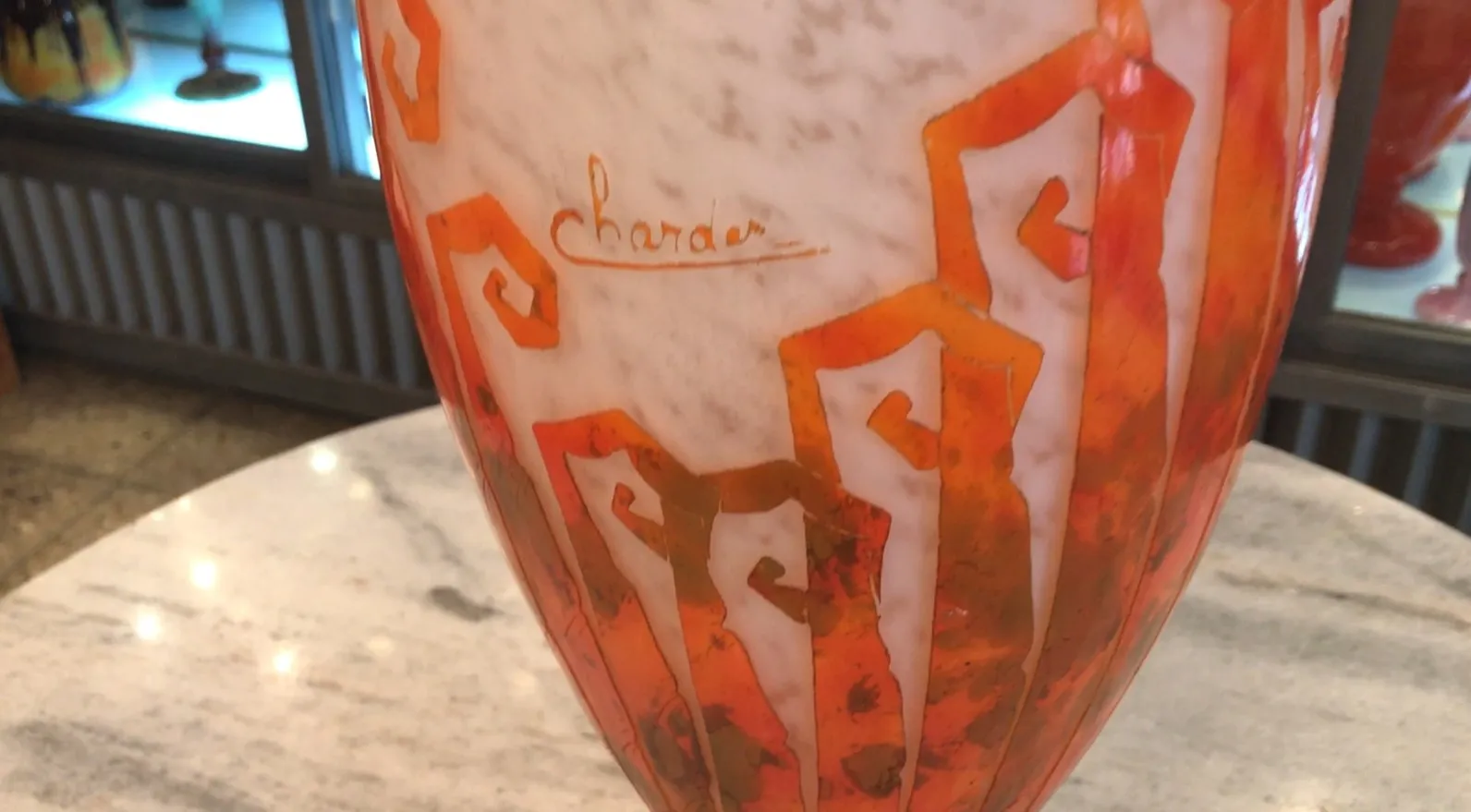 Vidrio firmado Charder con diseño colorido en naranja y blanco.