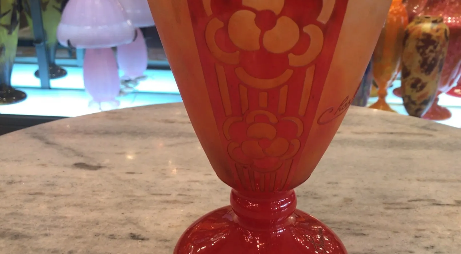 Verre signé par Charder en rouge et orange avec des détails décoratifs.
