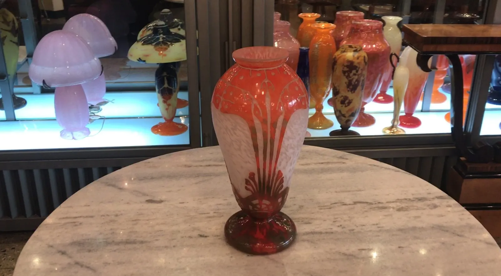 SIGNED GLASS Charder in an antique setting, with colorful objects in the background