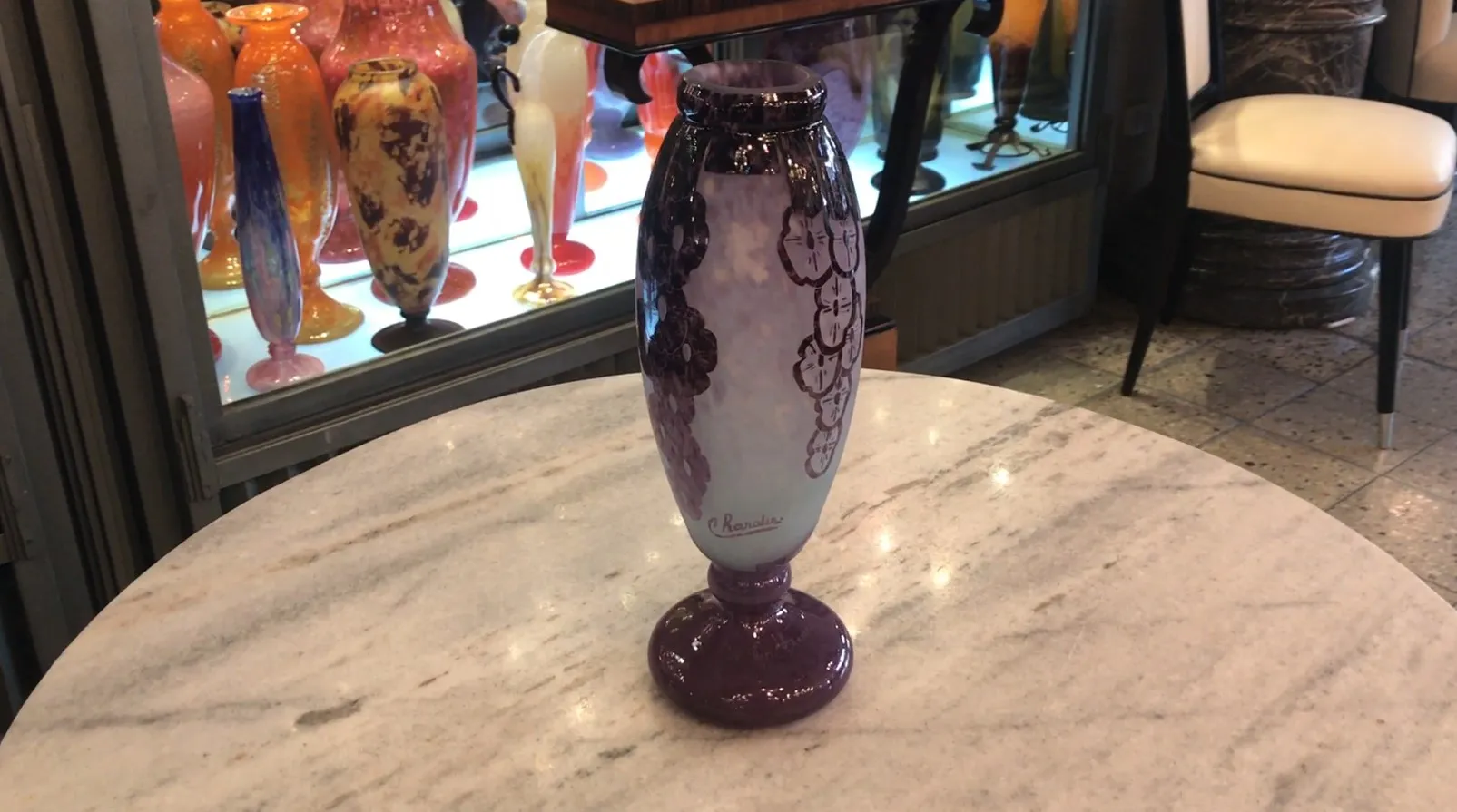 Signiertes Glas Charder mit lila Dekoren, hellem Hintergrund und floralem Relief.