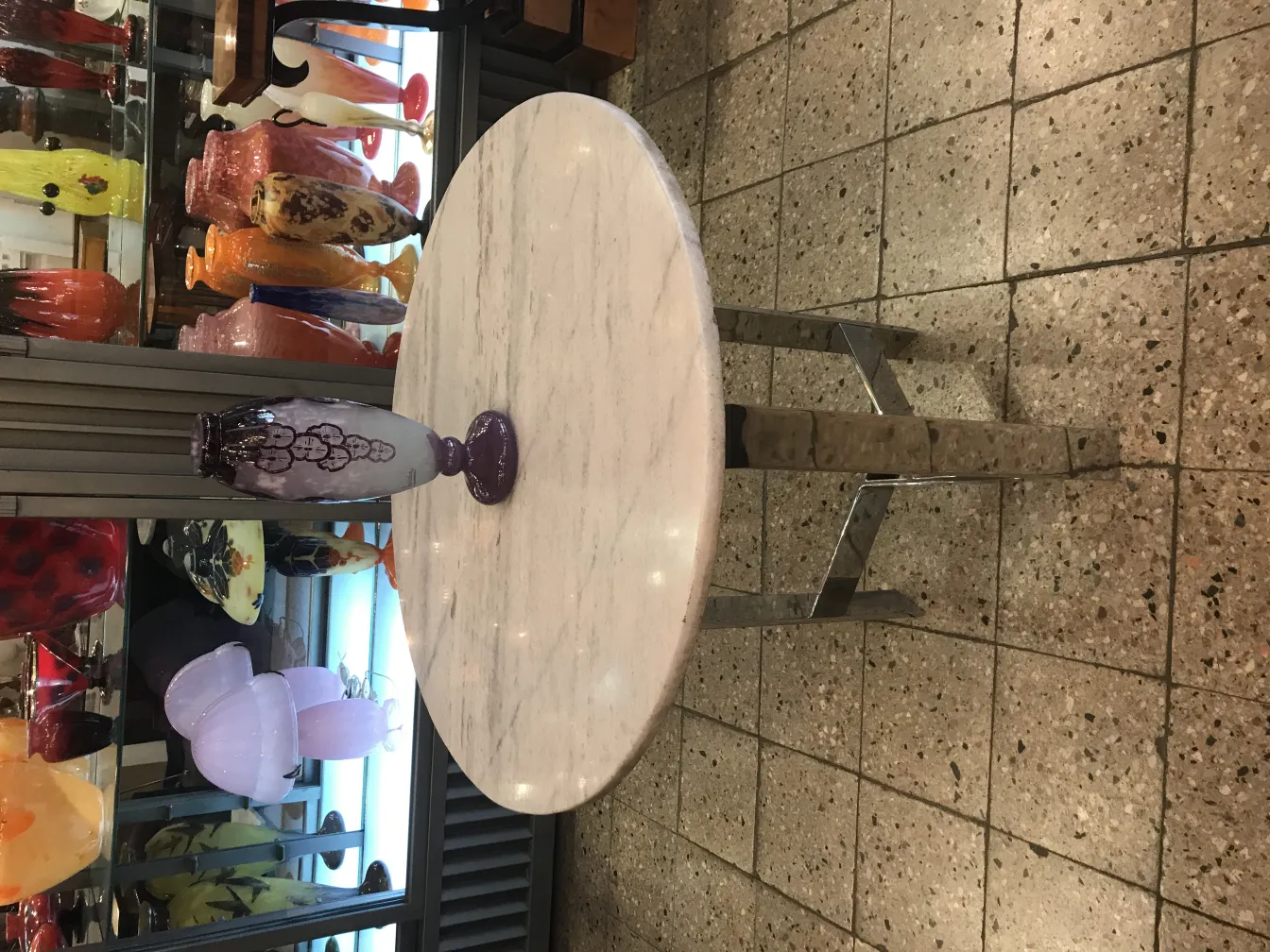 Vaso in vetro firmato Charder, antico pezzo francese esposto tra altre antichità colorate.