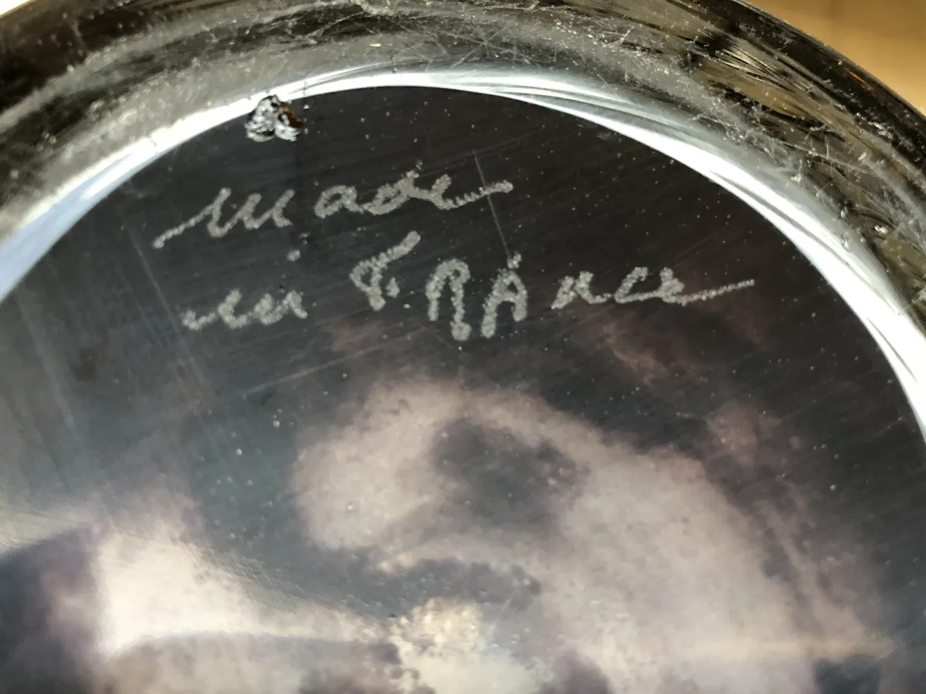 Verre signé Degué avec des détails distincts dans un cadre ancien.