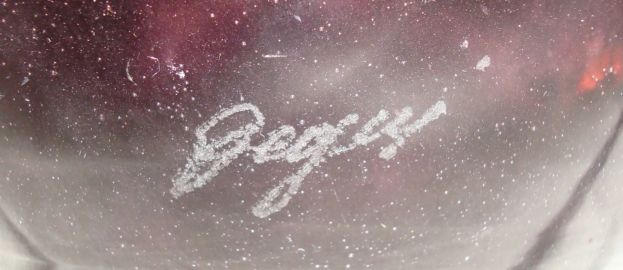 Vidrio firmado Degué con textura única y detalles sutiles, ambiente antiguo.