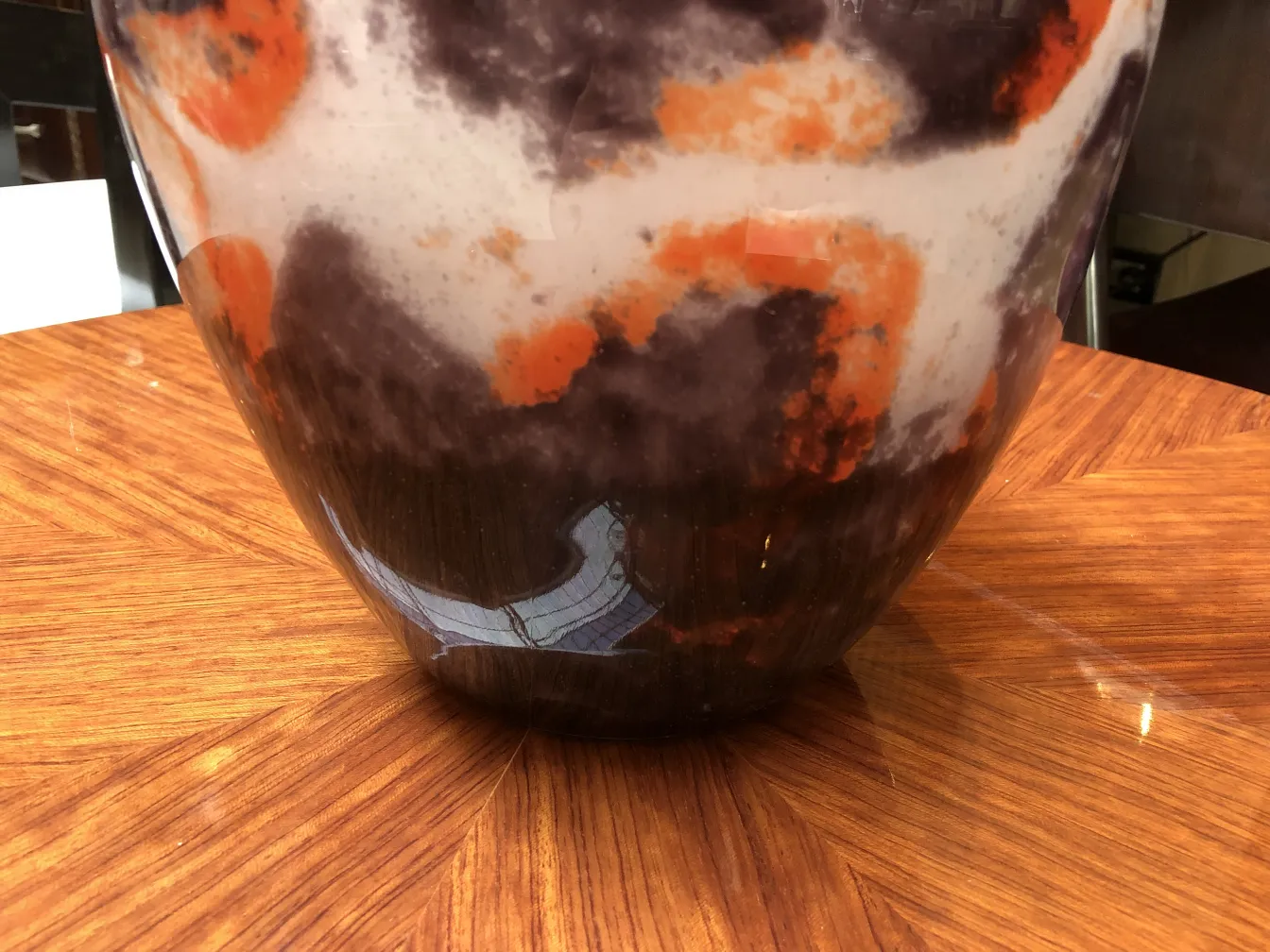 Verre signé Degué avec des tons sombres et oranges sur un fond élégant.