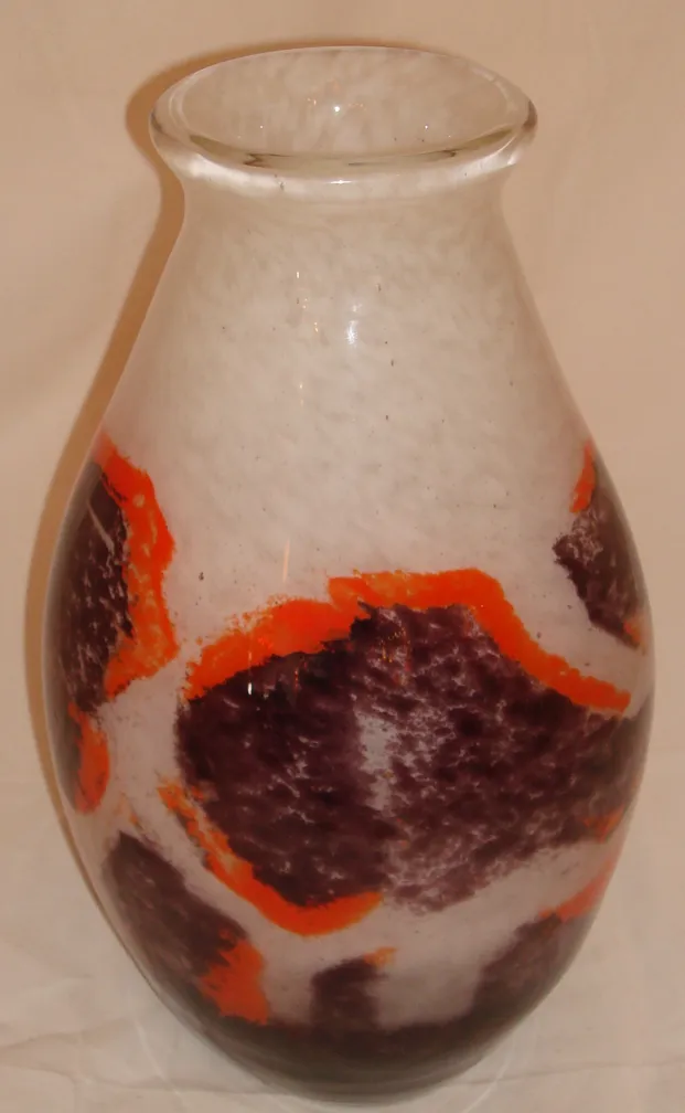 Vase en verre signé Degué, avec des décorations aux tons chauds créant un contraste visuel.
