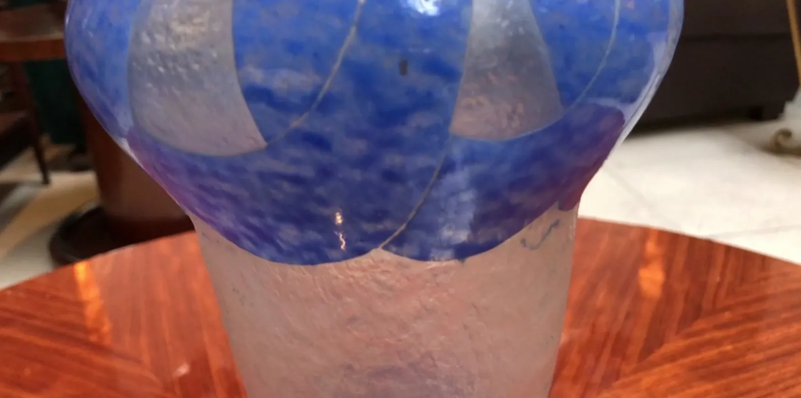 verre ancien signé Degué avec un design bleu et une base transparente sur une table en bois.