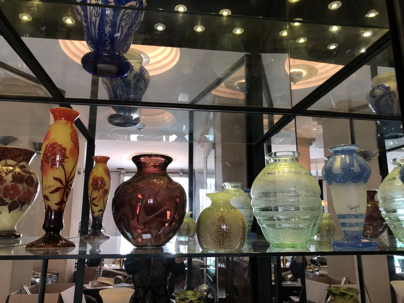 Coleção de antiguidades com vidro assinado Degué em uma vitrine