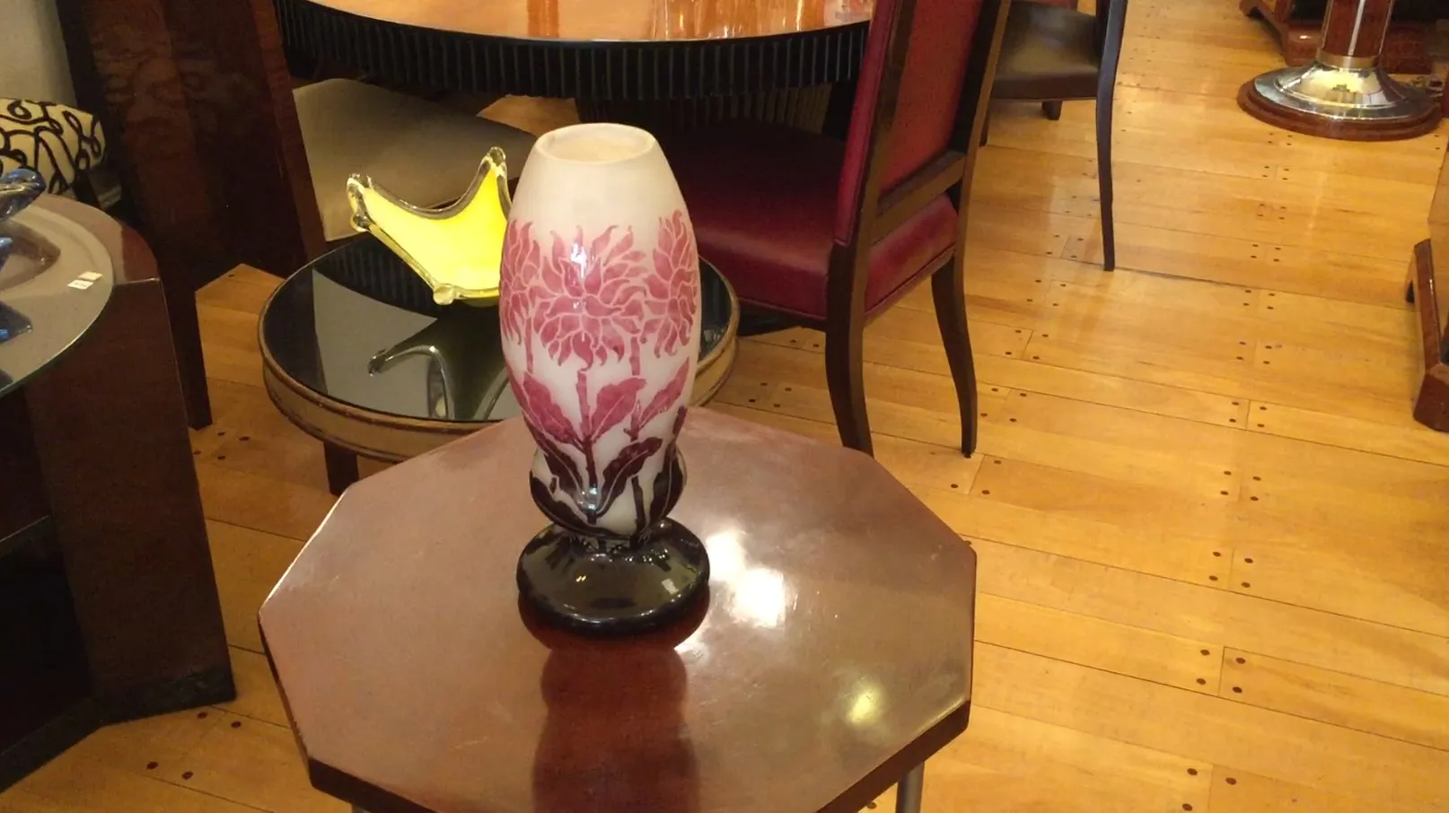 Vase en verre antique avec des gravures florales, élégant dans un cadre chaleureux.