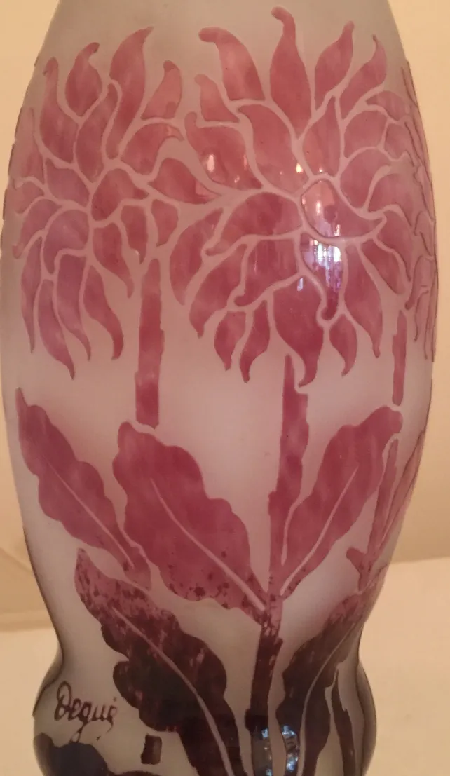 Vidrio antiguo Degué con diseño floral en relieve y firma decorativa.