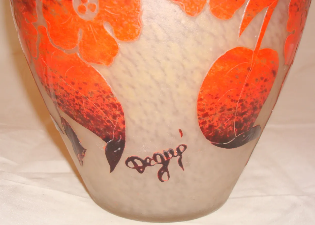 Antique glass with Degué signature on a decorative background.
