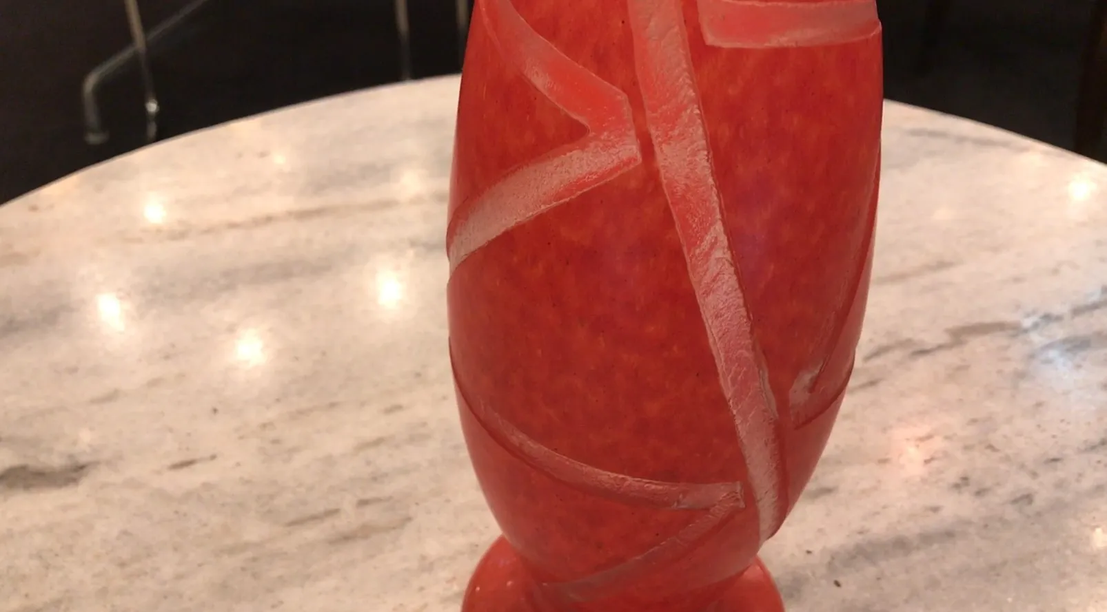 Vase décoratif en verre signé Degué avec motifs en relief, ambiance classique.