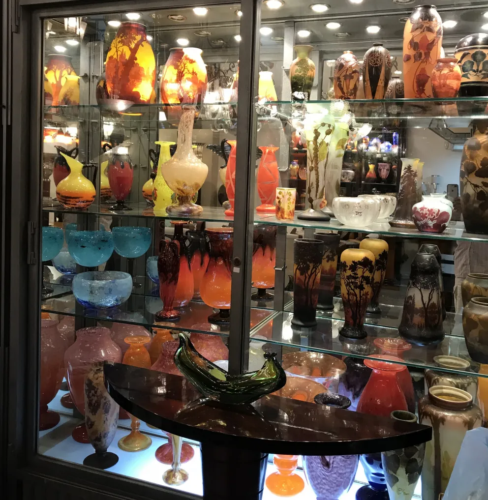 Collection of antique signed glass Degué on display