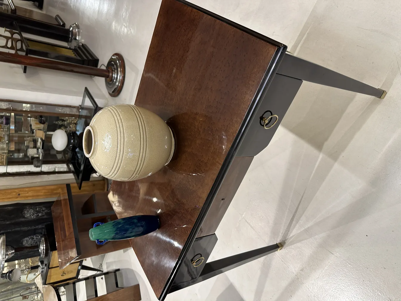 Mesa antiga com um vaso e uma garrafa em cima