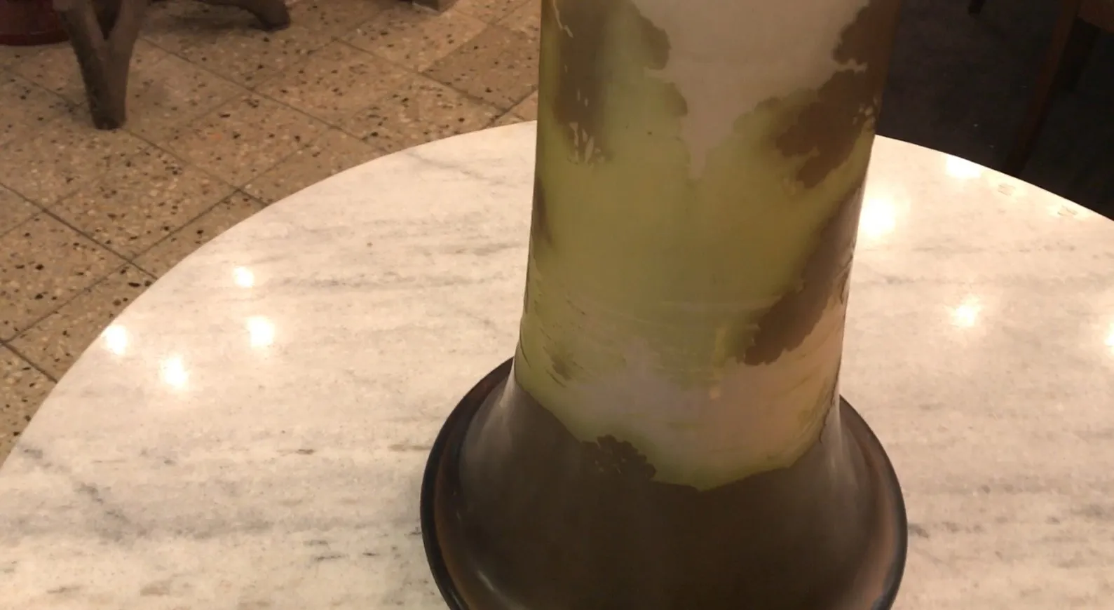 古董签名玻璃Galle，带有绿色和棕色细节，放在明亮的桌子上