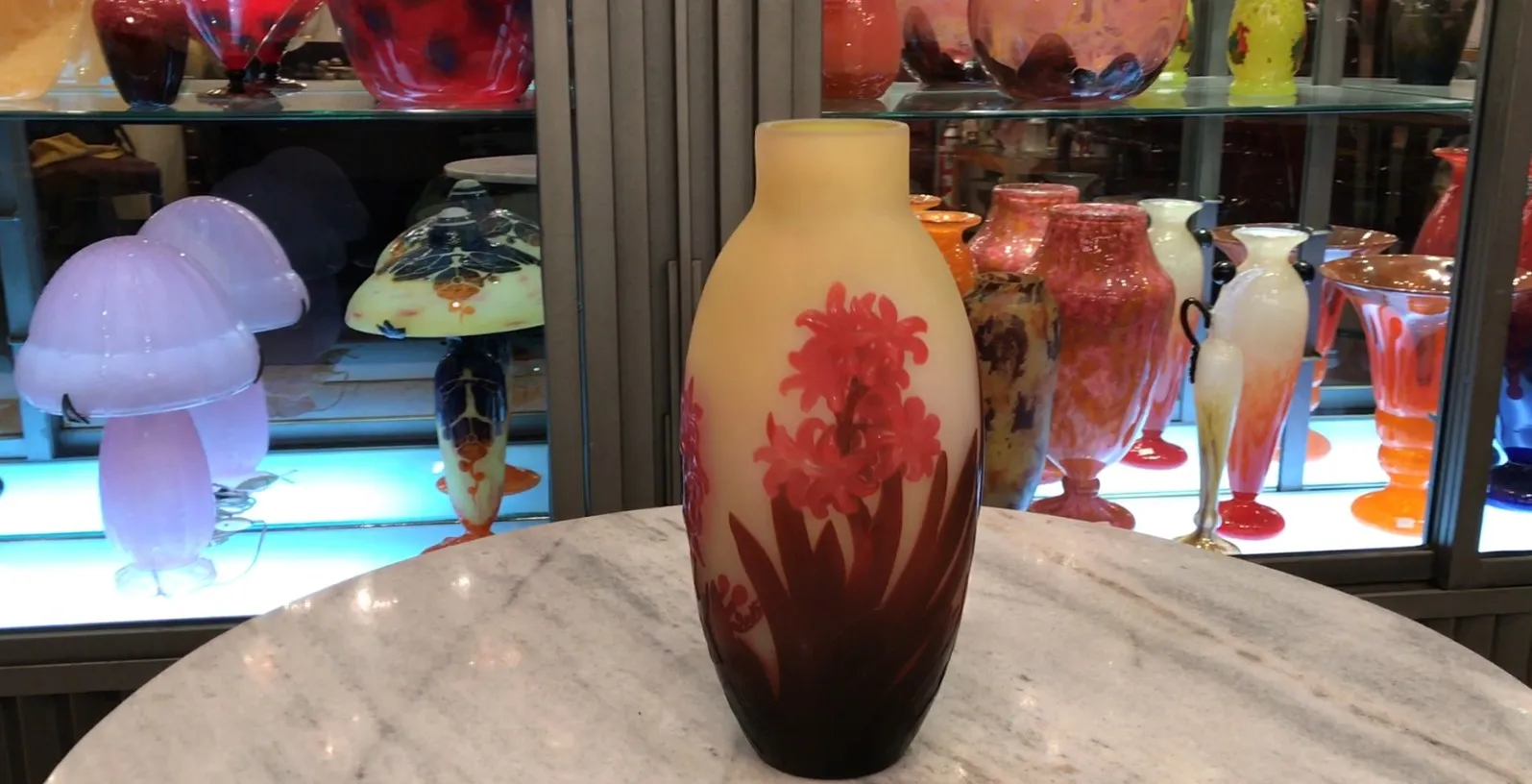 vase antico in vetro firmato gallé con fiori rossi e sfondo chiaro