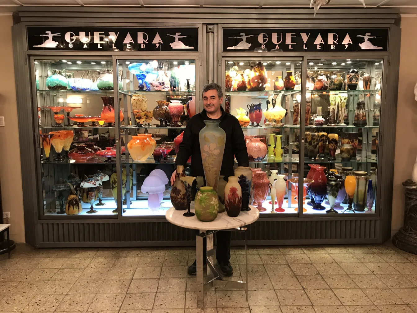 Vidro assinado Gallé cercado por outras antiguidades na galeria.