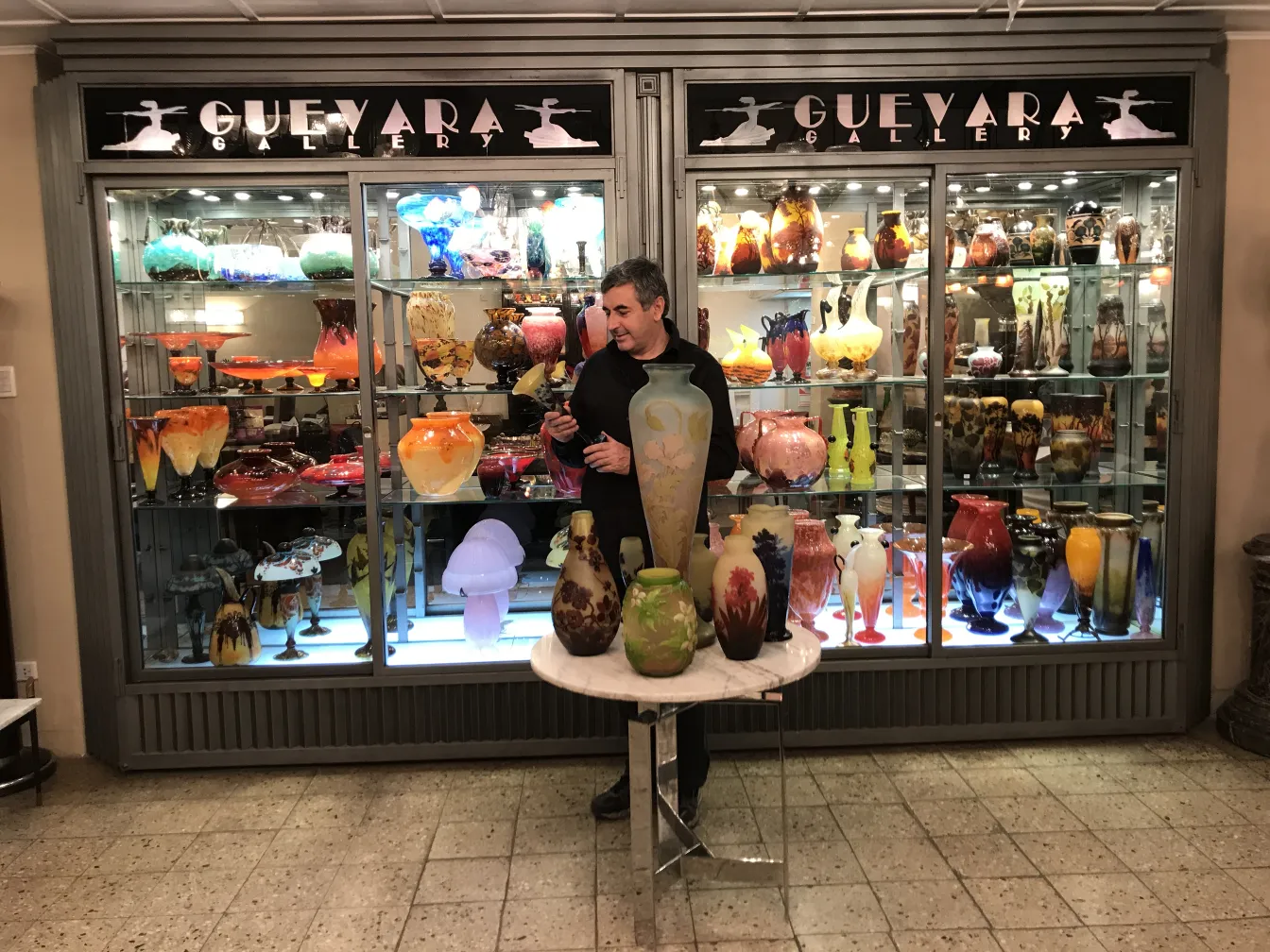 Verre signé Gallé exposé dans une galerie avec d'autres antiquités.