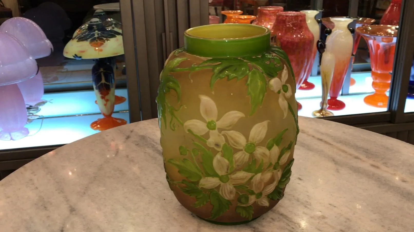 Antikes Gallé-Vase mit weißen und grünen Blumen, hellem Hintergrund, vintage Atmosphäre.