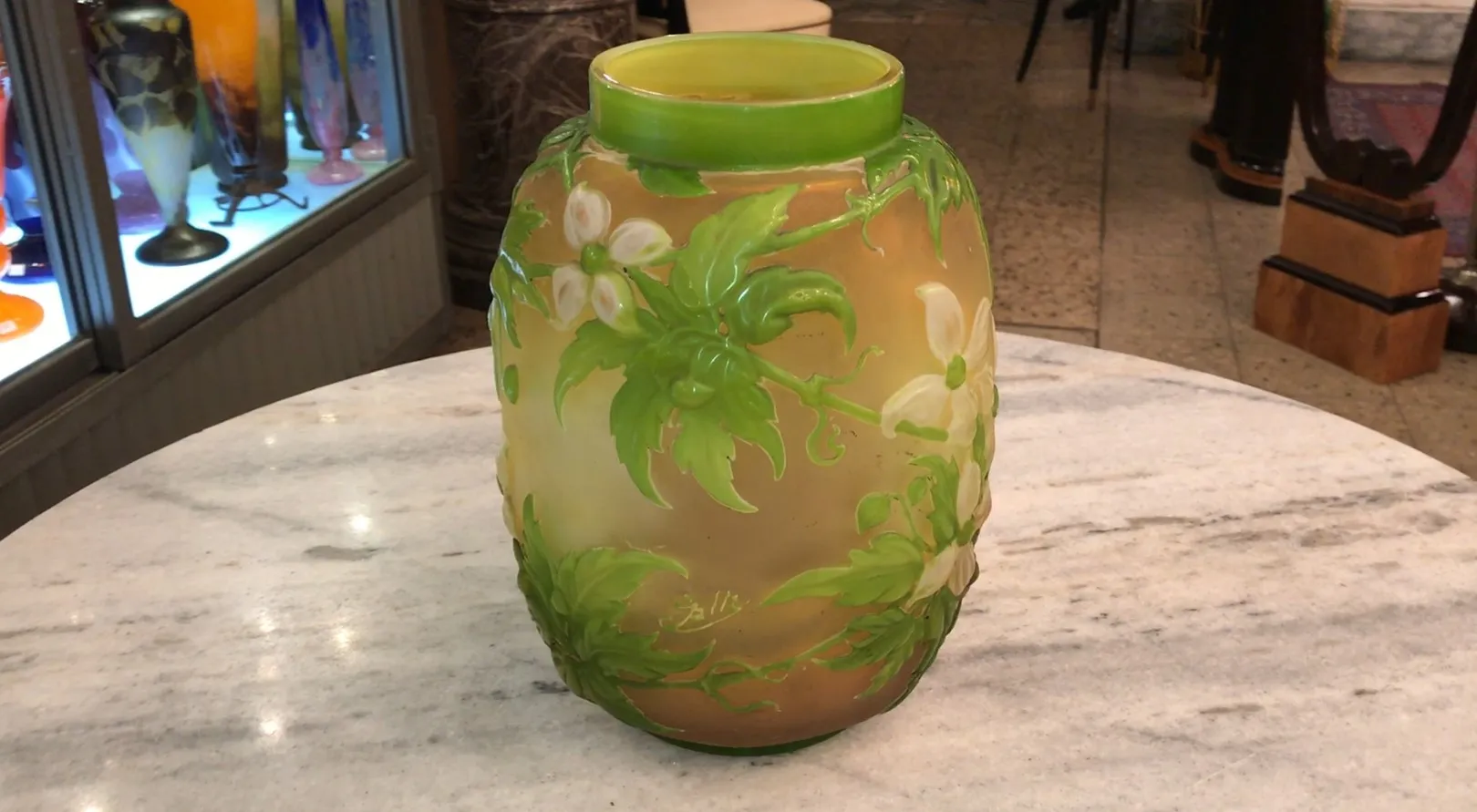 Vidro assinado Gallé com design floral colorido sobre fundo claro, ambientado em antiguidade.