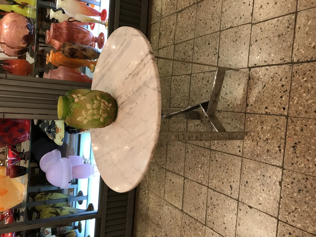 Vidrio firmado Gallé con decoración floral en un entorno de antigüedades.