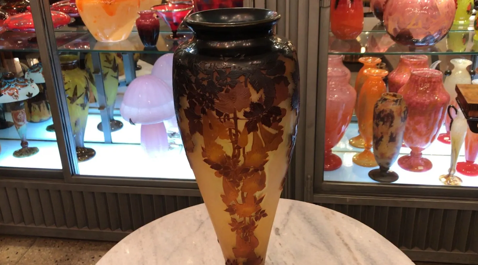 vase decorativo antico Gallé con design artistico, tra altri oggetti in vetro