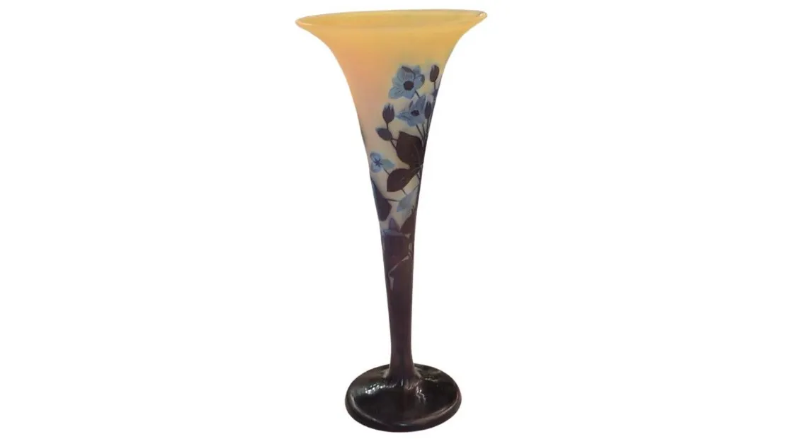 Tall glass vase with blue flower decoration and gradient background